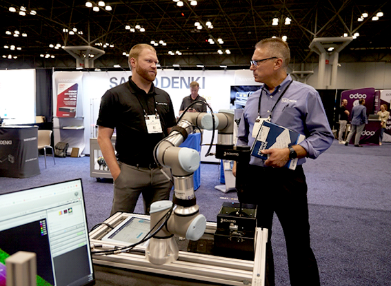 Attendees are looking robotic arms displaying on the expo hall